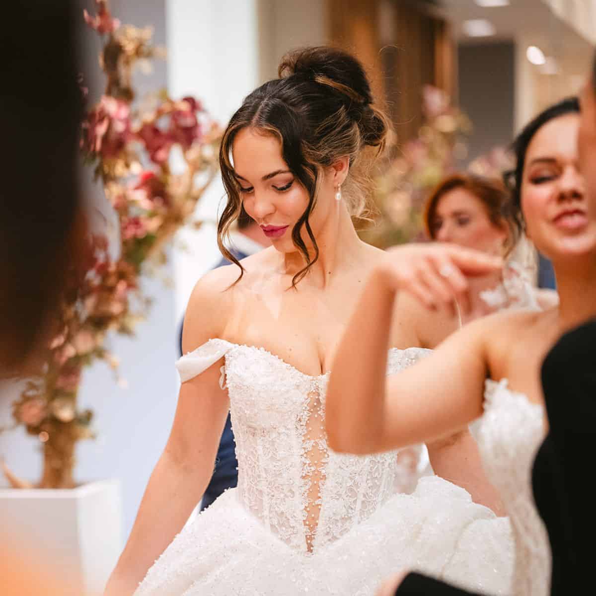 Model met trouwjurk met glitters en haar opgestoken in een bruidskapsel op de Weddings show