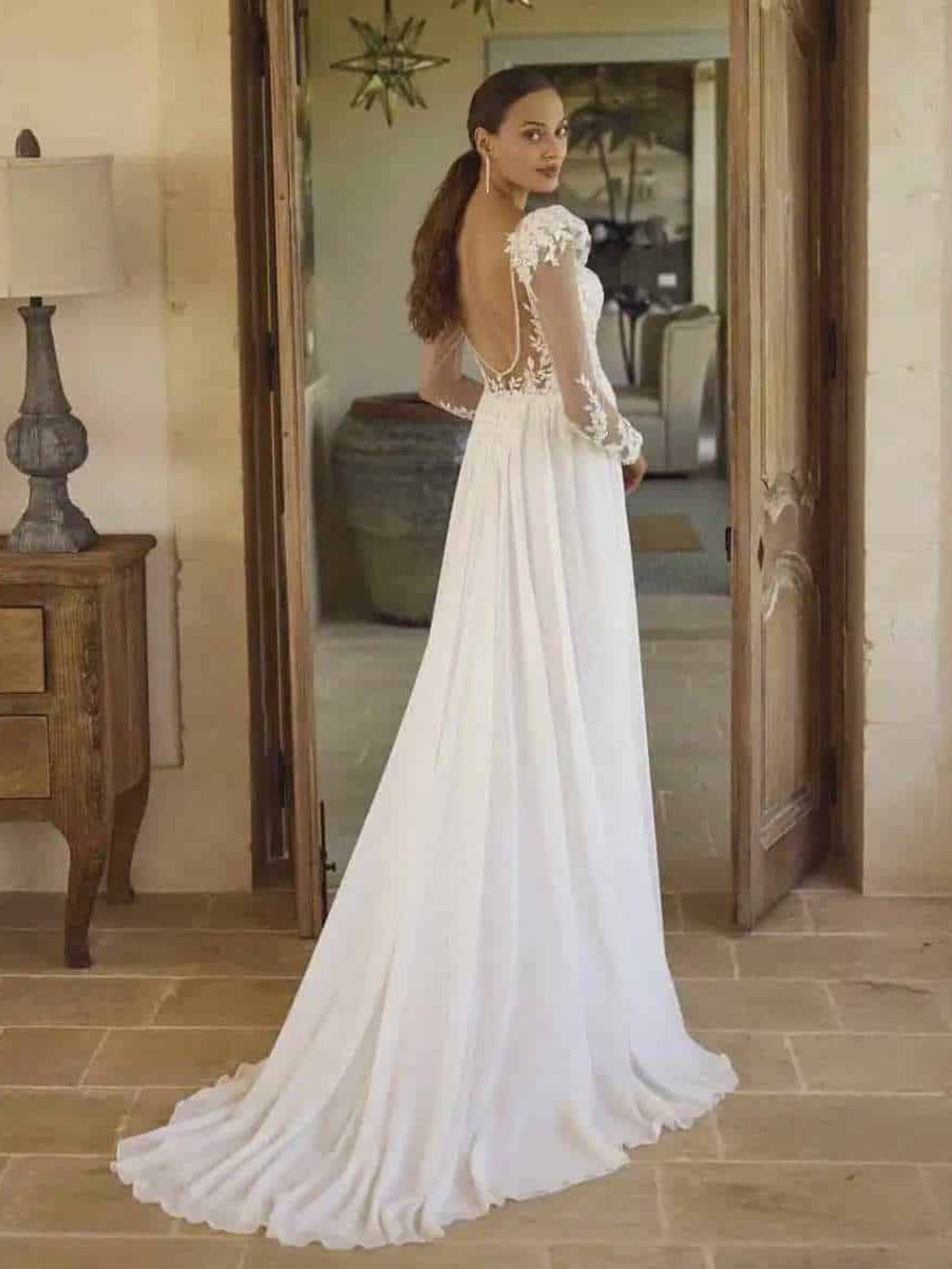 rechtvallende bruidsjurk van soepele stof met lange mouwen en blote rug